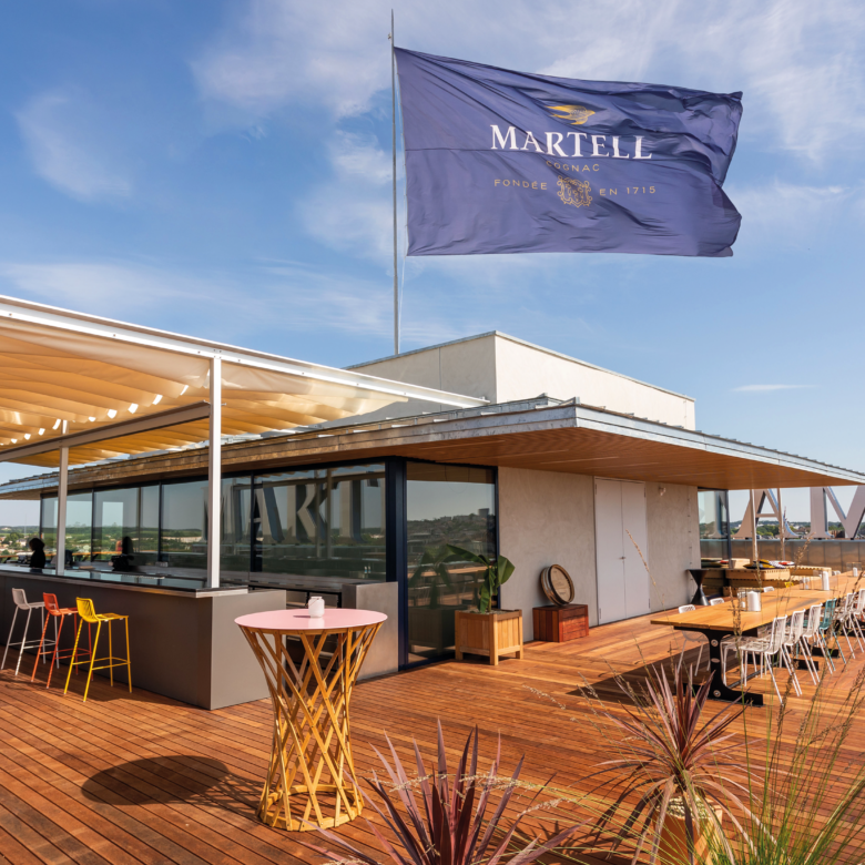 Un drapeau qui flotte dans les air sur la terrasse en bois exotique pour le rooftop de la tour martell à Cognac en france