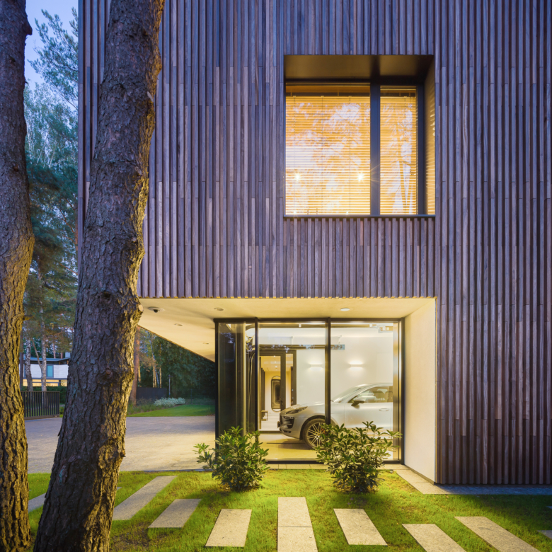 voiture dans un garage d'une maison moderne avec une une façade en bois exotique en padouk