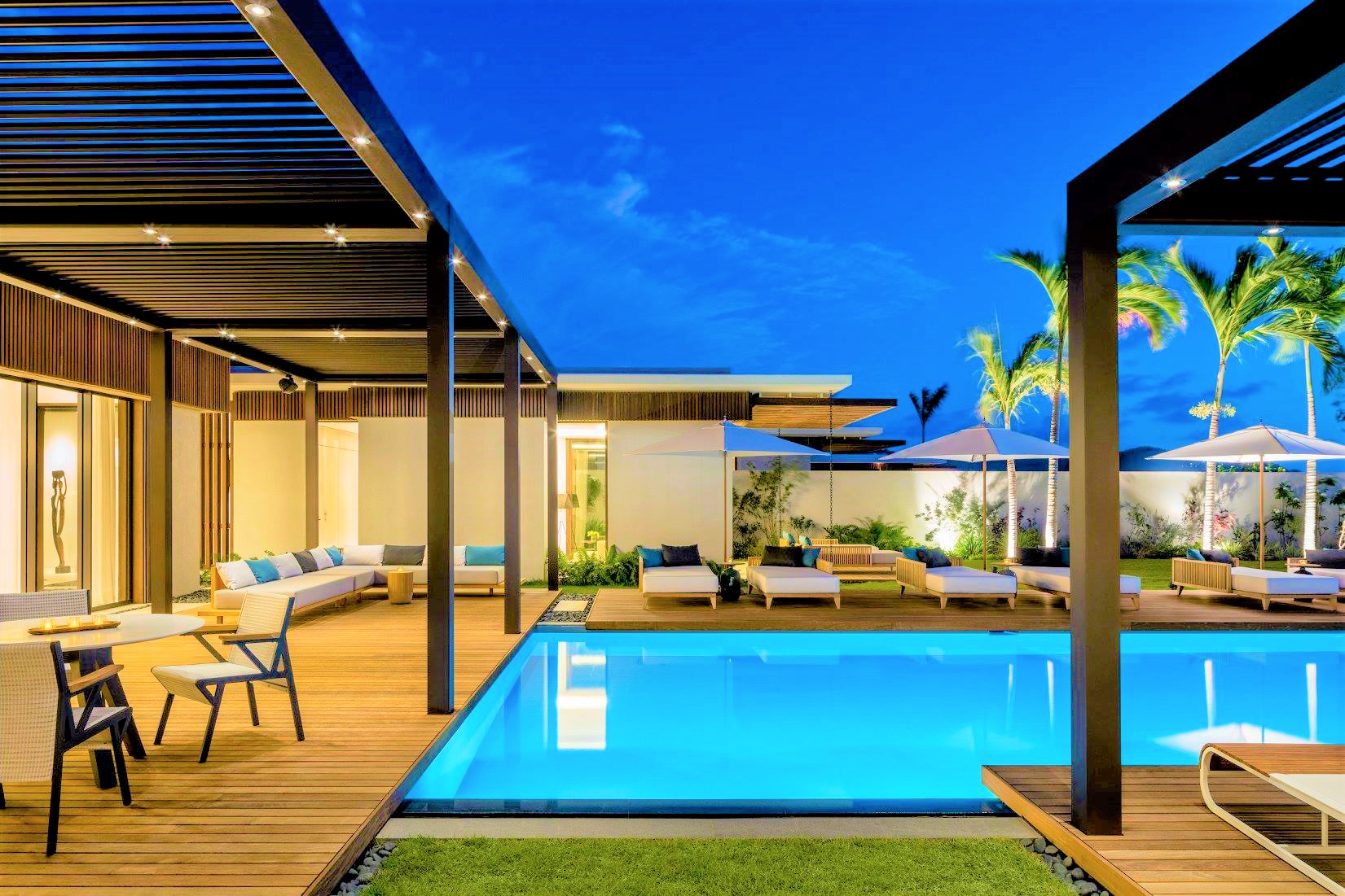 Grande piscine avec palmiers et terrasse Softline en bois exotique Teak et Ipé sous un ciel bleu à l'Hôtel Silversands aux îles Grenade